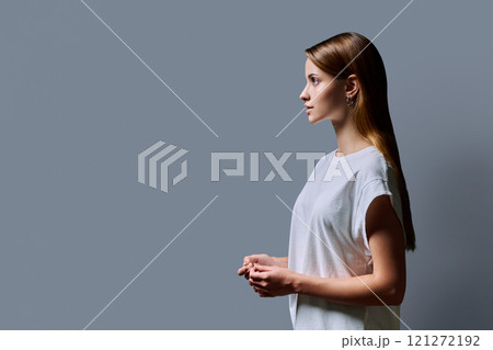 Profile portrait of young teenage girl, gray studio copy space background 121272192