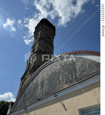 Historic Brick Tower with Mural Under Blue Sky 121272341