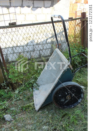 garden Wheelbarrow on the grass. Cottage equipment and use garden Wheelbarrow on the grass. Cottage equipment and use 121272381