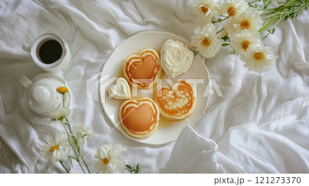 Heart-shaped pancakes on a cozy table setting. 121273370