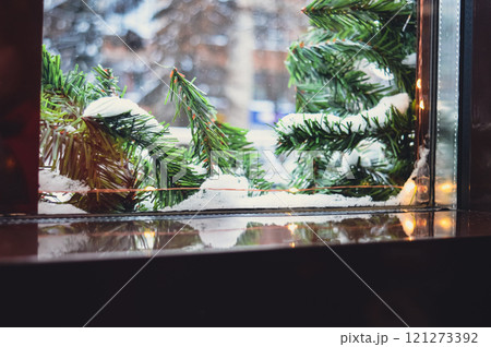 a Christmas window sill on which you can put something. there is a fir tree garland and snow outside the window. High quality photo 121273392