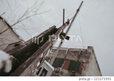 a gloomy winter shot of a metal cable supporting a rusty pipe in the heating room of factory shops in Europe. High quality photo 121273393