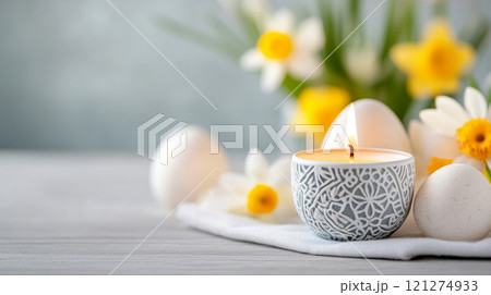 Decorative Easter Candle with Eggs and Yellow Flowers on Wooden Table. Spring Holiday Celebration 121274933