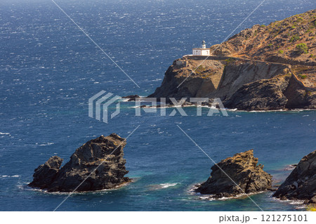 Cala Nans lighthouse on a rocky coastline on a sunny day, Cadaques, Spain 121275101