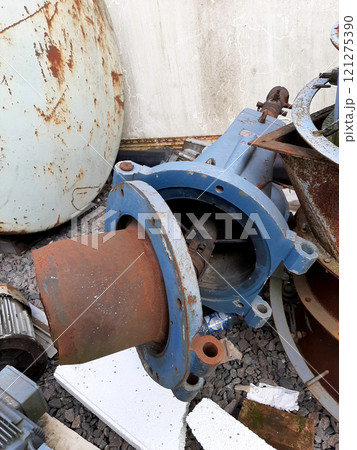 Old Diesel Boiler Burner Resting on Scrap Metal at an Industrial Site 121275390