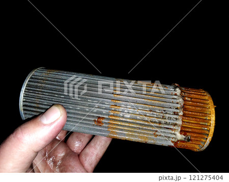 Fuel Filter Mesh With Impurities Showing Signs of Wear and Contamination in a Workshop Setting 121275404