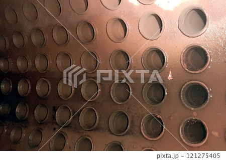 Holes pipes in steam boiler drum. Brown rust and lime deposits on the walls 121275405