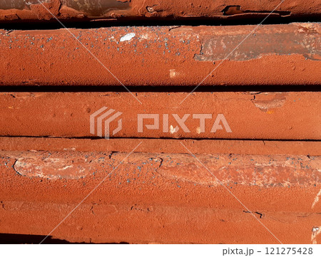 Horizontal pipes from an industrial gas-fired steam boiler are covered with rusty limestone deposits 121275428