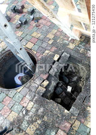 Repairing a Sewage Well With Cobblestone Surface Collapse During Maintenance Work Repairing a Sewage Well With Cobblestone Surface Collapse During Maintenance Work 121275430