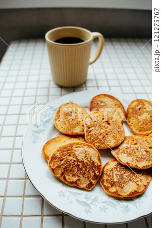coffee and pancakes on plate on kitchen table, breakfast on sunny morning. healthy eating 121275767