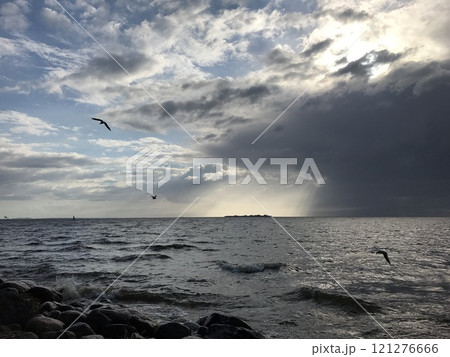 Storm clouds, rain and sun over the sea 121276666