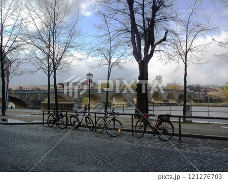 Bicycles on the embankment of the river Danube near the stone bridge in Germany, Regensburg. Bicycles on the embankment of the river Danube near the stone bridge in Germany, Regensburg. 121276703