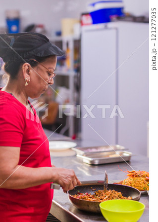 Latin american chef preparing traditional ecuadorian dish in restaurant kitchen 121277035