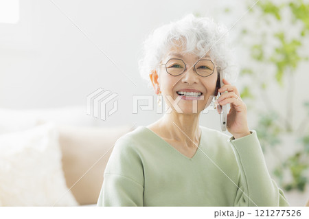 リビングで電話するシニア女性 　 121277526