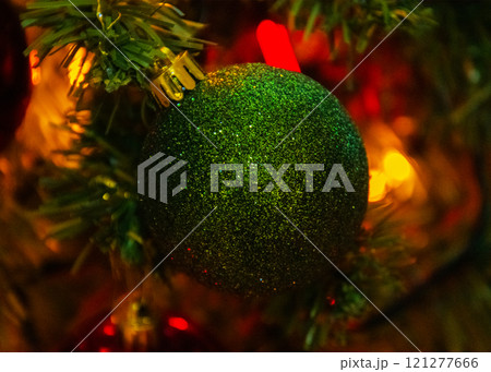 A vibrant green ball is hanging gracefully from a Christmas tree A vibrant green ball is hanging gracefully from a Christmas tree 121277666