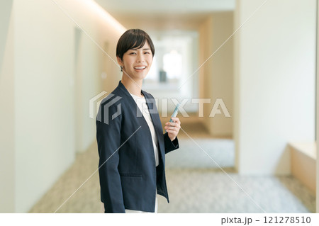 オフィスの廊下で微笑むスーツの女性 121278510