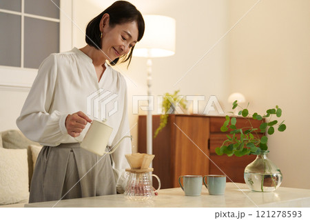 夜にコーヒーを淹れるミドル女性 121278593