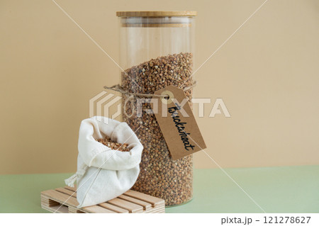 Raw buckwheat porridge in sustainable natural packaging. Refillable systems. Gluten free cereals. Health gut benefits. Concept of alternative whole spelt grain ingredient. Vegetarian diet recipes 121278627