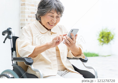 スマートフォンを操作する車椅子のシニア女性 121278720