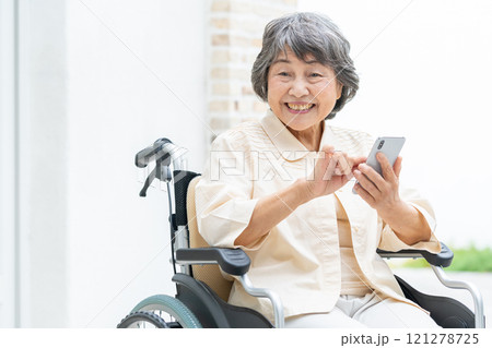 スマートフォンを操作する車椅子のシニア女性 121278725