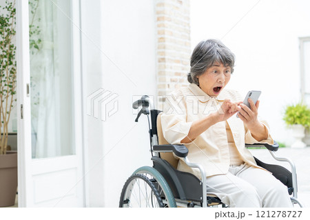 スマートフォンを操作する車椅子のシニア女性 121278727