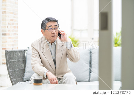 スマートフォンで会話するシニア男性 121278776