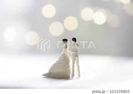 光の中で寄り添うウェディングドレスのカップル 121278903