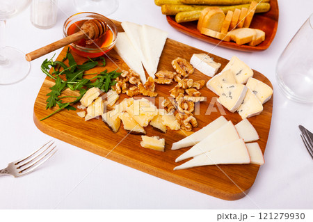Varieties of cheese sliced and served with honey 121279930