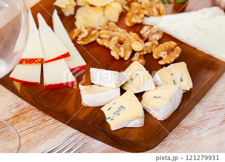 Various types of cheese on wooden board 121279931