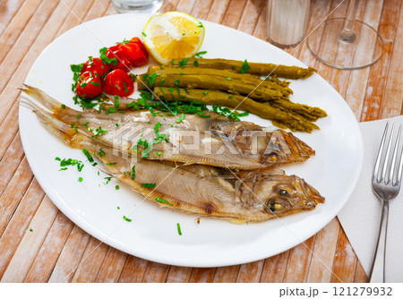 Fried roosterfish with asparagus, tomatoes and lemon Fried roosterfish with asparagus, tomatoes and lemon 121279932