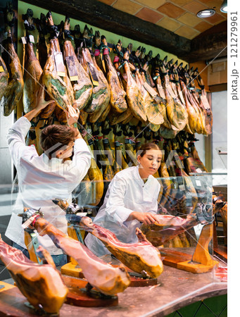 Young salesgirl and salesman of butcher shop selling Iberian jamon 121279961