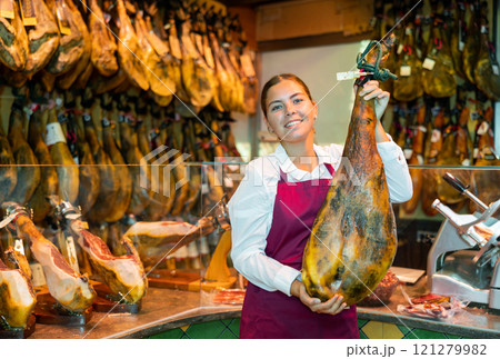Ordinary owner of butcher shop selling traditional spanish jamon Ordinary owner of butcher shop selling traditional spanish jamon 121279982