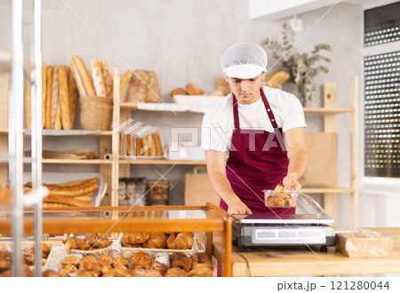 Skilled young baker weighing freshly baked pastries Skilled young baker weighing freshly baked pastries 121280044