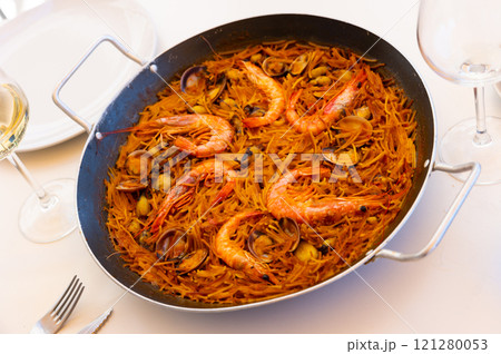 Traditional spanish seafood dish fideua with aioli sauce in restaurant 121280053