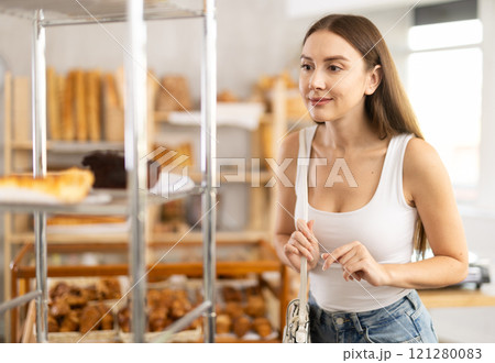 Young female customer chooses something in bakery Young female customer chooses something in bakery 121280083