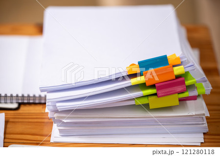 Paper documents are stacked on wooden desks at the workplace. 121280118