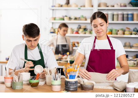 Young woman and young man making pottery Young woman and young man making pottery 121280527
