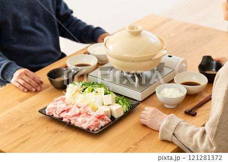 家で豚肉のしゃぶしゃぶ鍋を楽しむミドル夫婦 家で豚肉のしゃぶしゃぶ鍋を楽しむミドル夫婦 121281372