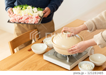 家で豚肉のしゃぶしゃぶ鍋を楽しむミドル夫婦 121281485