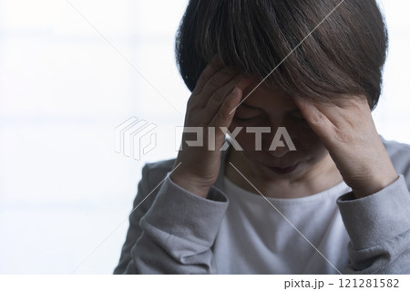 顔を手で覆うシニア女性  121281582
