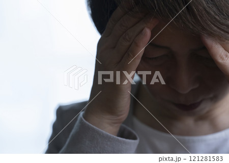顔を手で覆うシニア女性  121281583
