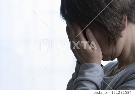 顔を手で覆うシニア女性 顔を手で覆うシニア女性 121281584