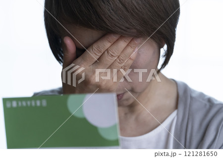 顔を手で覆うシニア女性 通帳 121281650