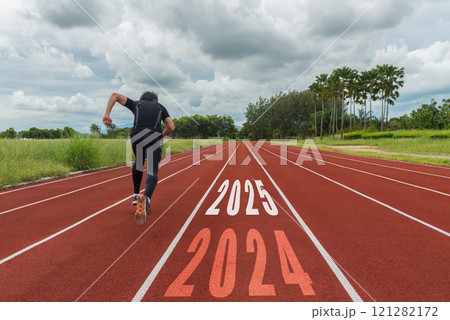 The start into the new year 2025. Start up of runner woman running on nature race track go to Goal The start into the new year 2025. Start up of runner woman running on nature race track go to Goal 121282172