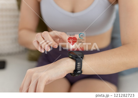 Women Point to smartwatch displaying heart rate application. Monitoring virtual display measure heart rate before after physical exercise. wristwatch checking heart beats and pulse. Women Point to smartwatch displaying heart rate application. Monitoring virtual display measure heart rate before after physical exercise. wristwatch checking heart beats and pulse. 121282723