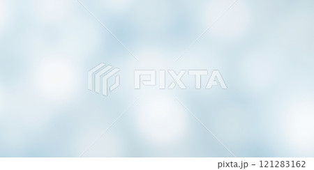 Soft focus winter background with gentle snowfall on light blue sky perfect for holiday season 121283162