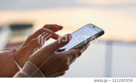 《AI画像》スマートフォンを操作する手元 121285359