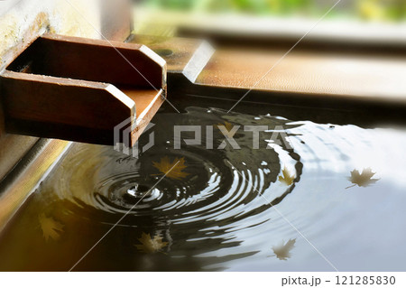 紅葉の落ち葉が浮かぶ檜の露天風呂　湯口から落ちる一滴のしずくと美しい水紋　葉のグラフィック合成素材 121285830
