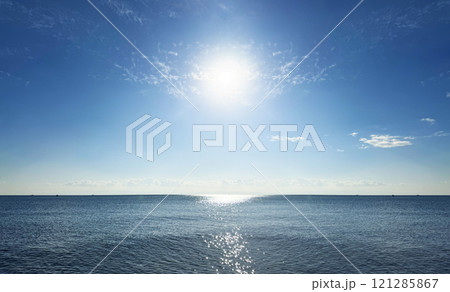 太陽の光を浴びてキラキラと光る海の波景色と美しい地平線 121285867