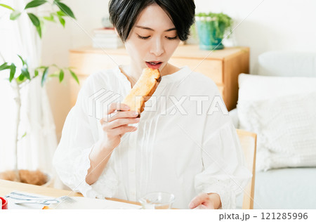 食事中にスマホを見る若い女性 121285996